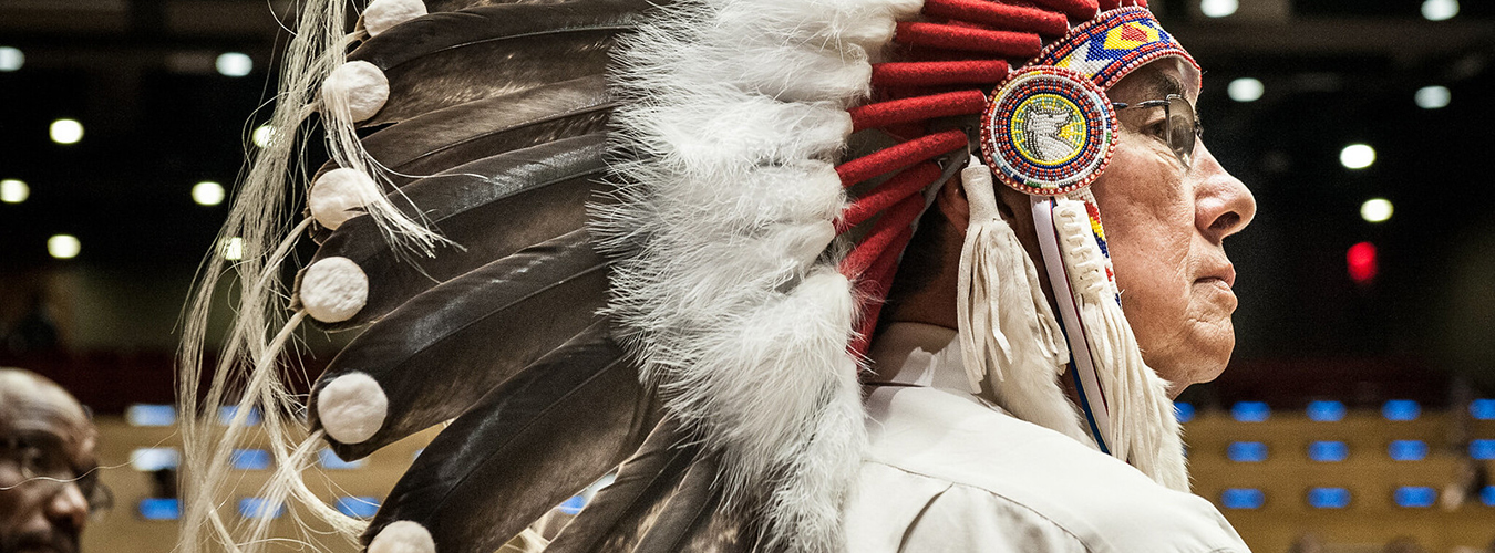 Profile photo of Grand Chief Wilton Littlechild, a Cree Chief from Canada, in his traditional head-dress.